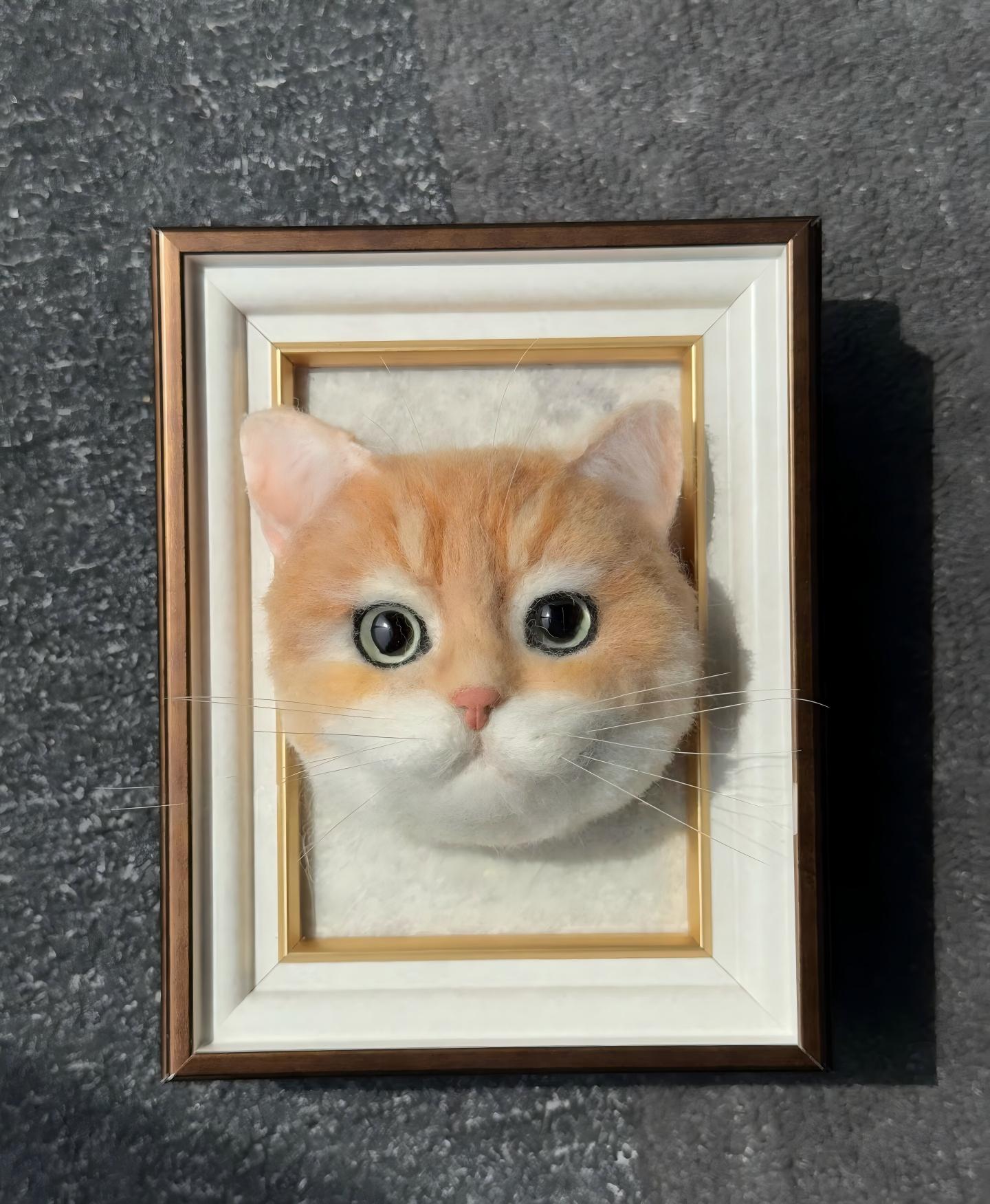 Framed orange kitten portrait with large eyes and light whiskers