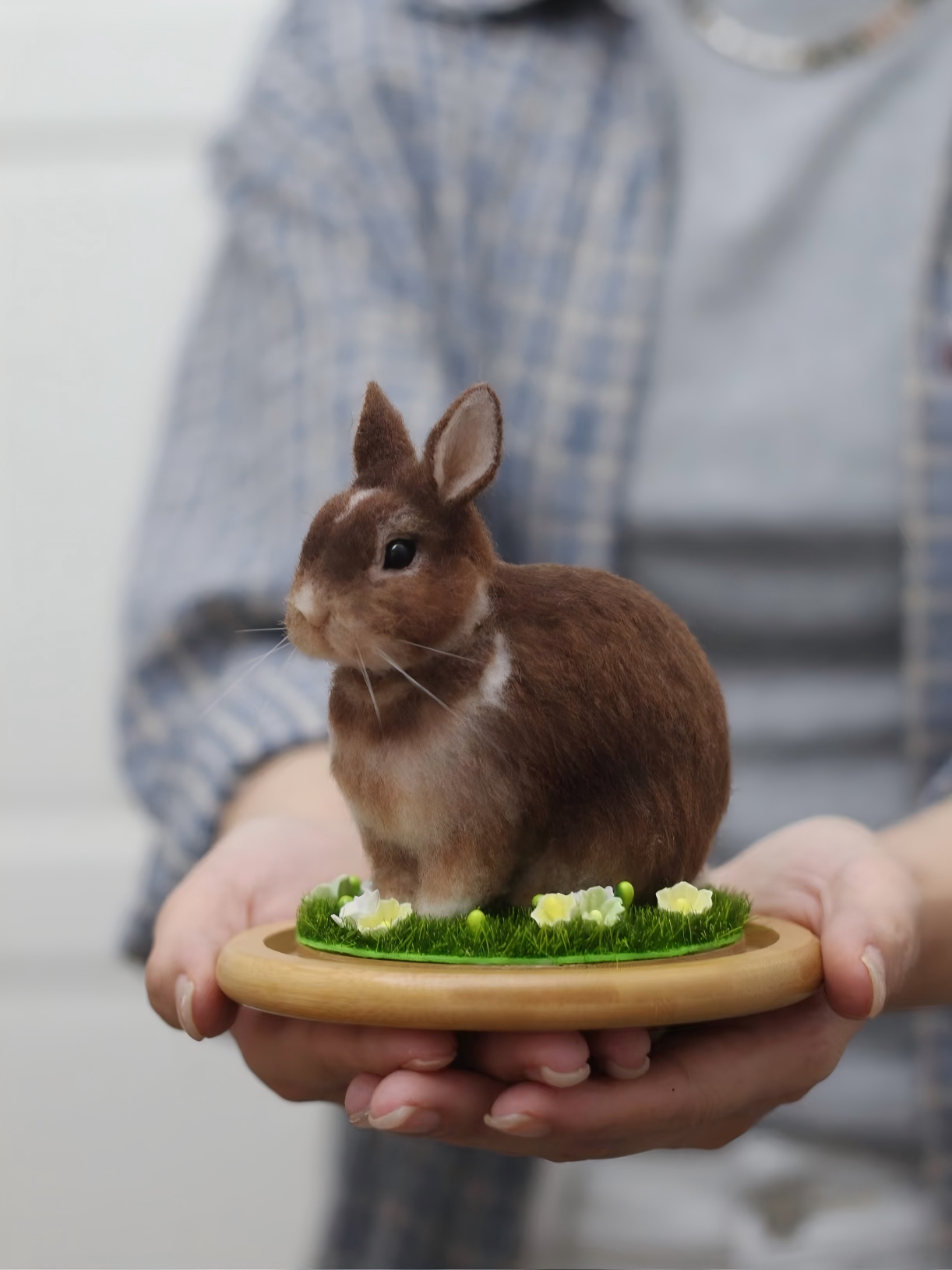 Plush rabbit custom pet on round tray with green grass, held in hands