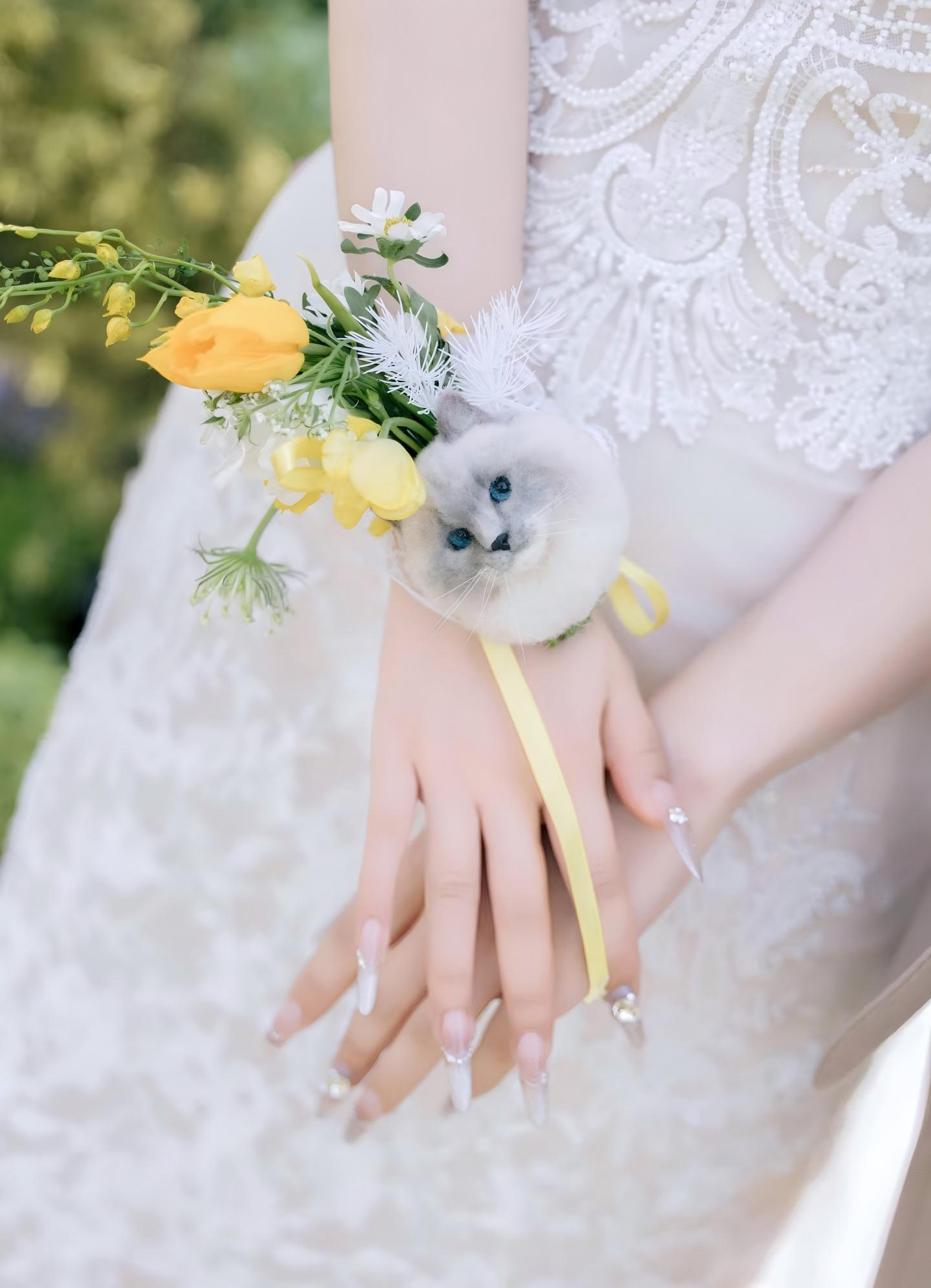 Pet souvenir white cat plush held with a small bouquet of yellow and white flowers