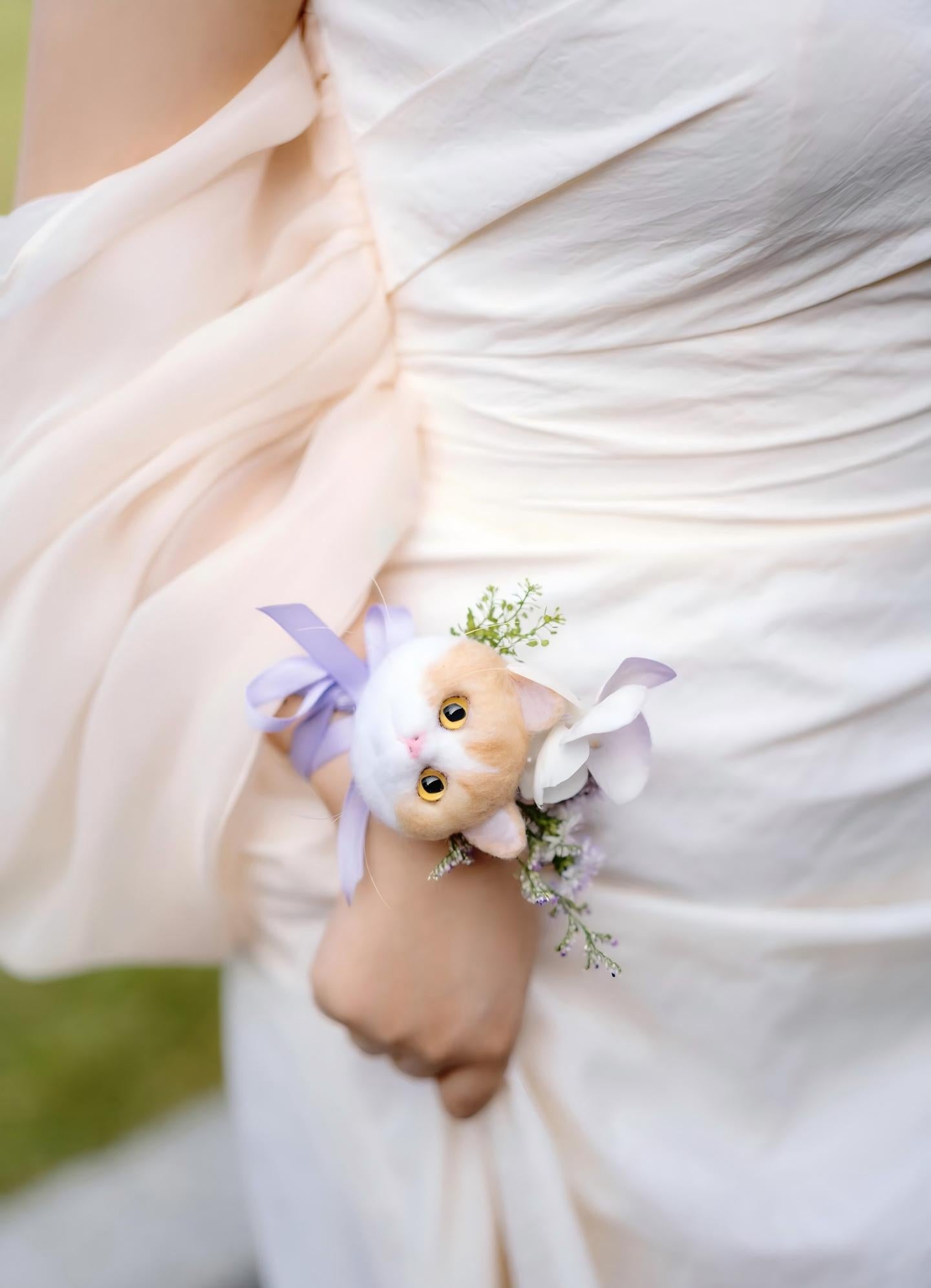 Small cat head keepsake with blue ribbon bow and flower sprigs