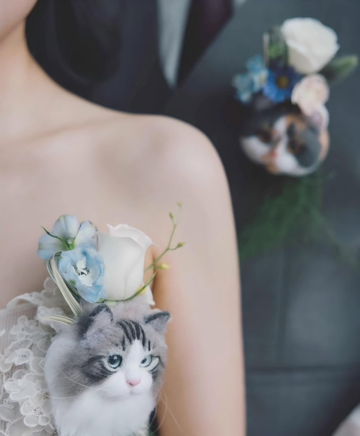 Cat head keepsake with light blue flowers, gray tabby plush, and ribbon