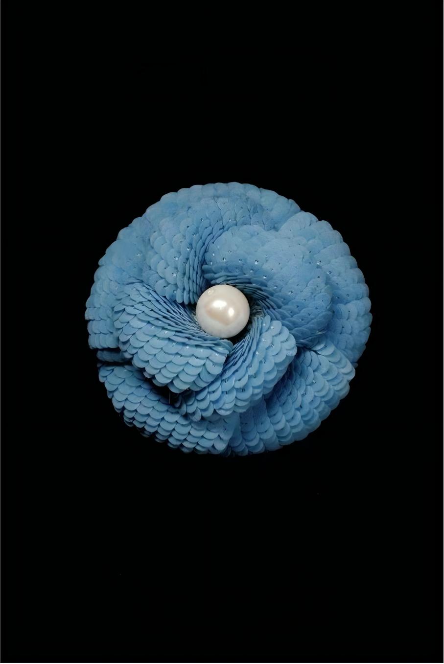Light blue camellia brooch with sequined petals and a white pearl in the center