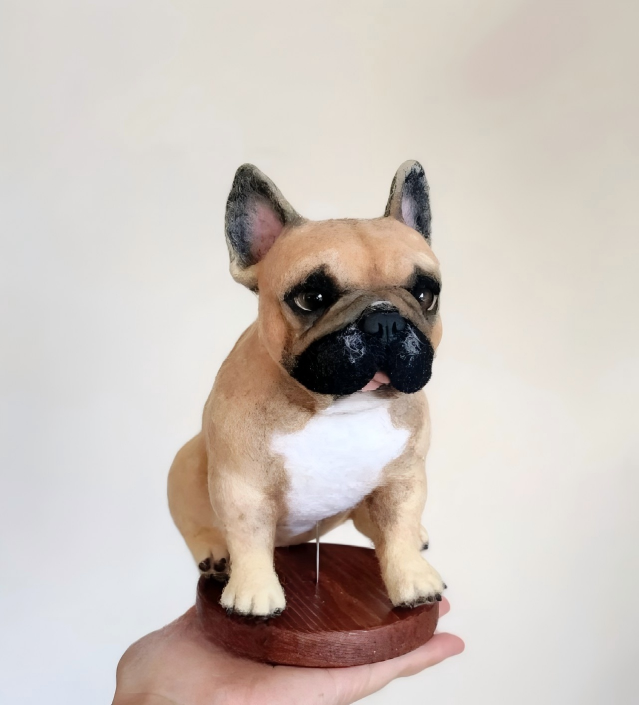 Brown French bulldog figurine on a round wooden base