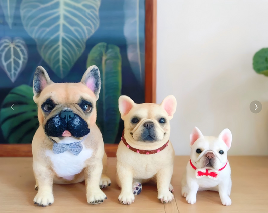 Three small dog figurines: blue-eyed cat, red collar, and white pup